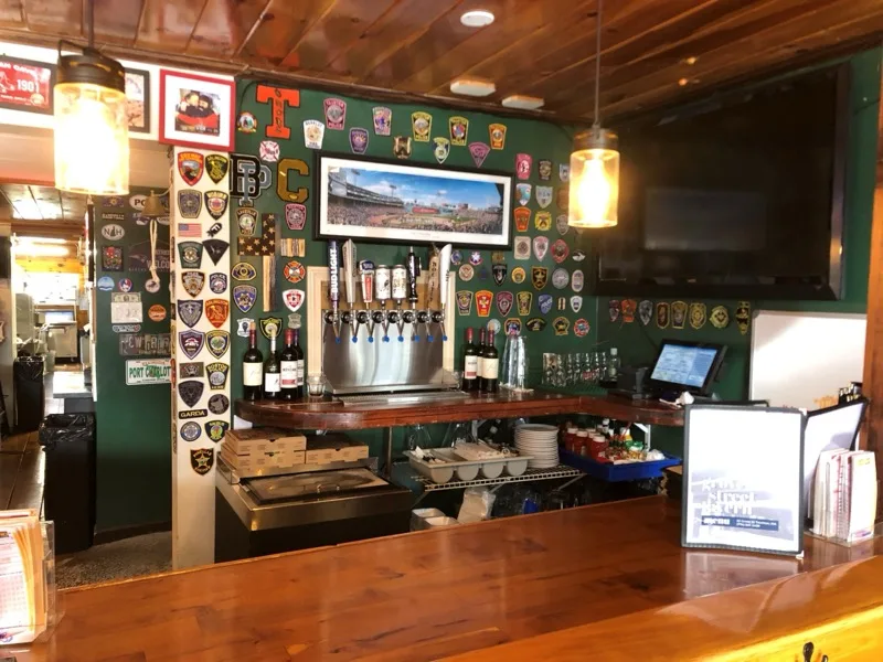Full bar with tap handles and TVs at Grove Street Tavern